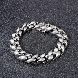 Detailed view of silver Cuban link bracelet featuring intricate skull relief accents
