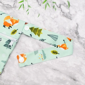 Detail of waterproof diaper bag with forest fox print and snapping handle strap