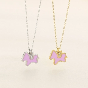 Close-up of unicorn pendant necklaces with pink enamel and sparkling inlaid crystals
