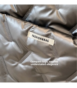 Détail du tissu matelassé métallisé argenté avec étiquette FASHION & BAG sur un sac cabas