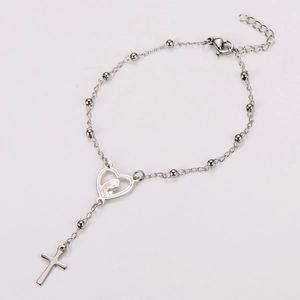 Détail macro du bracelet rosaire en acier inoxydable avec pendentif coeur et croix