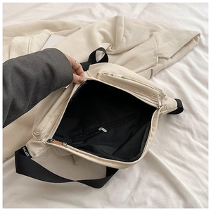 Detail of crossbody bag showing the black interior compartment and inner zipper pocket