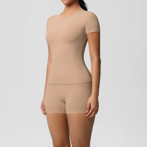 Detailed close-up of beige high-elastic fitness set featuring slim-fit top and shorts