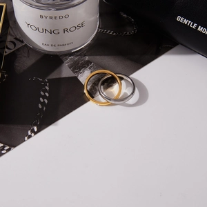 Minimalist gold and silver stainless steel rings with zircon accents on chic background
