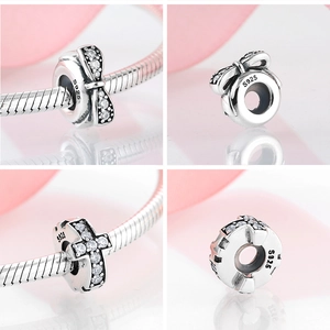 Macro detail of S925 sterling silver cross and bow spacer beads with clear gemstones