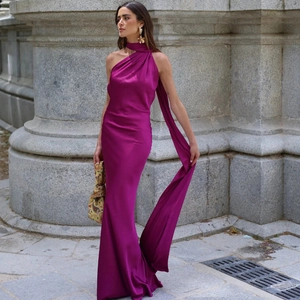 Elegant magenta silk maxi dress with one-shoulder ribbon detail against classical columns
