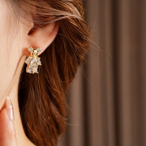 Close-up of gold plated bear earring with cubic zirconia crystals on a model
