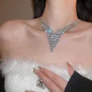 Detail of silver V-shaped tassel necklace with sparkling rhinestones on elegant model
