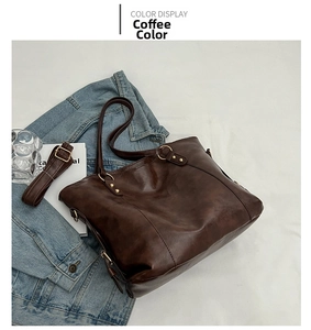 Detail of coffee brown tote bag with premium leather texture and vintage gold hardware