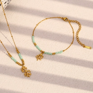 Detail of gold coral branch necklace and matching green stone bead bracelet set