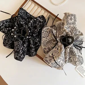 Elegant bandana print hair claw clips with pearls and ribbon bows in black and beige