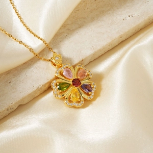 Elegant gold flower necklace with colorful zircons on a luxury satin and stone background