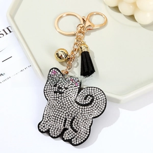 Detail of sparkling crystal cat keychain with black tassel and golden hardware