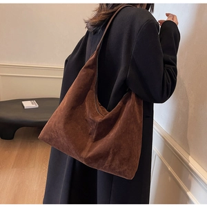 Detail of dark brown suede hobo bag showing large capacity and soft matte texture