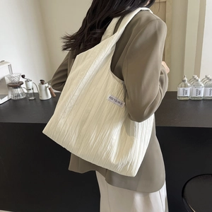 Schicke beige gerüschte Umhängetasche mit Kiss Yourself Label in modernem Café
