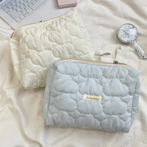 Detailed cloud-pattern quilted makeup bag featuring smooth metal zippers and silk ribbons