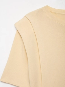Close-up of ribbed round neckline and layered shoulder detail on beige knit crop top