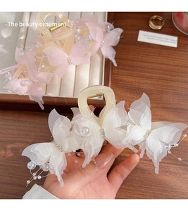 Detail of butterfly hair claw with sheer wings, sparkling crystals and pearl tassels