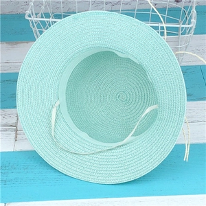 Gros plan de l'intérieur du chapeau de paille vert menthe avec texture et jugulaire