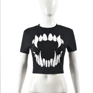 Détail du crop top noir avec imprimé graphique de dents de démon blanches sur la poitrine