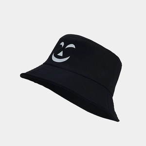 Detail shot of black cotton bucket hat featuring a white pumpkin face print on the side