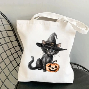 Sac cabas en toile blanche avec imprimé chat noir et citrouille d'Halloween sur chaise noire