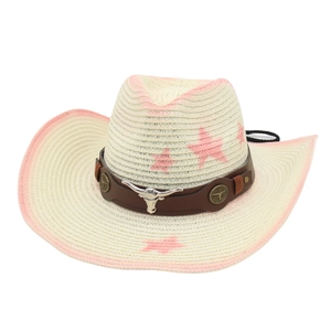 Dettaglio di cappello da cowboy in paglia con stelle rosa ed emblema testa di toro