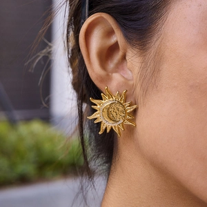 Elegant gold celestial earrings featuring sun and moon design with sparkling crystals