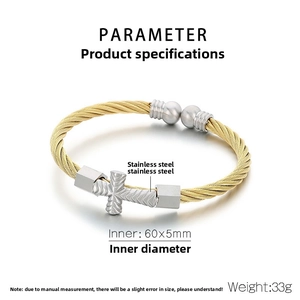 Detail of twisted cable stainless steel bangle with a silver cross and gold accents