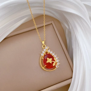 Detail of gold water drop necklace with red gem and sparkling crystals on jewelry box