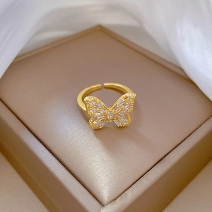Adjustable gold butterfly ring with white cubic zirconia on beige satin jewelry box