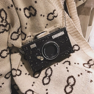 Sparkly black camera shaped crossbody bag with star pattern and metal chain strap