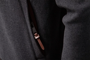 Detailed macro view of the metal zipper with premium brown leather pull on a gray hoodie