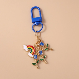Detail view of rainbow cloud and blue rose pendants with gold chain and blue spring clasp