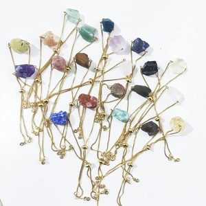 Macro view of adjustable gold chain bracelets with various raw natural crystal stones