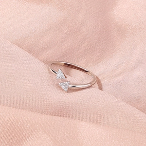 Close-up of adjustable silver ring with two triangle zircon stones on silk fabric