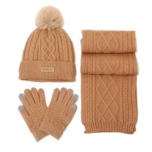 Close-up of caramel knit winter set showing the leather bear patch and cable texture