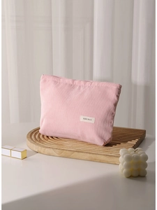 Pink corduroy makeup bag with H&R BAG patch on a decorative wooden tray setup