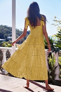 Detail of yellow gingham tiered maxi dress with self-tie shoulder straps and ruffled skirt