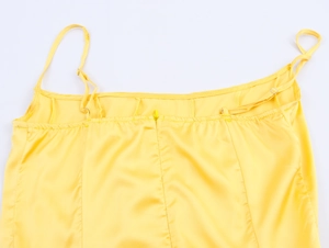 Detail of yellow satin dress back showing thin straps and invisible zipper closure