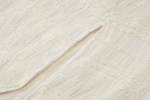 Vue macro de la texture du tissu plissé blanc et détails froncés de la robe d'été