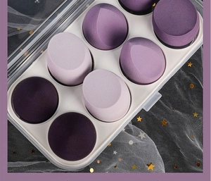 Macro shot of 8 purple makeup sponges in a clear box on a black starry background