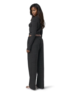 Detail of classic black and white striped long-sleeve top and high-waist wide-leg pants