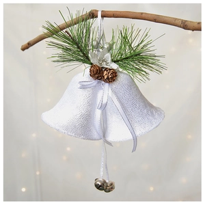 Close-up of white velvet bells with pine needles and cones on a festive branch