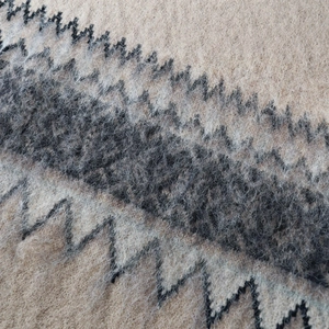 Chic beige knitted sweater with charcoal zigzag patterns and soft fuzzy texture