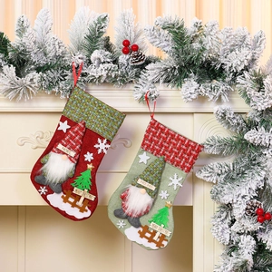 Large burlap Christmas stockings with 3D faceless gnome decor hanging on a festive fireplace
