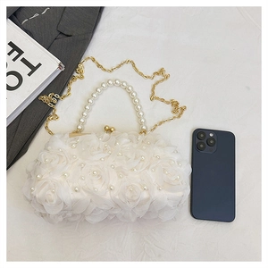 Détail de fleurs en dentelle 3D et perles sur un petit sac à bandoulière blanc élégant