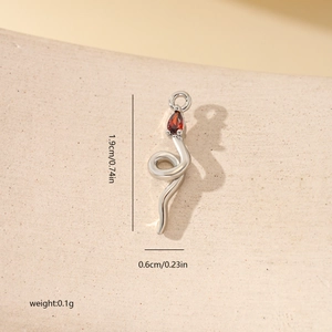 Détail du pendentif serpent argenté avec pierre rouge et marquages de dimensions