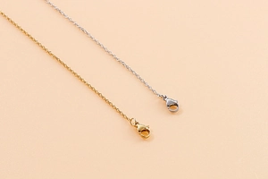 Detail of gold and silver lobster clasps on minimalist basic jewelry chain necklaces