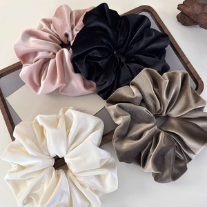 Set of 4 oversized velvet scrunchies in pink black cream and brown on wooden tray